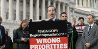 Ein Abgeordneter bei einer Rede mit dem Capitol im Hintegrund , am Rednerpult eine Texttafel: MAGA COP's Bogus Impeachment: Wrong Priorities
