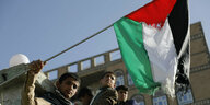 Ein Junge in Jemen schwenkt die palästinensische Fahne