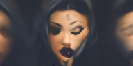 Mit künstlicher Intelligent generiertes Selbstporträt der Künstlerin, einer Frau mit dunklem Haar, herzförmigem und stark geschminktem Gesicht