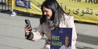 Mariam Claren am Rande einer Demonstration mit dem Foto ihrer im Rina inhaftierten Mutter Nahid Taghavi