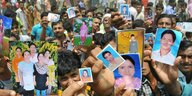 Menschen zeigen Fotos ihrer Angehörigen, die sie vermissen, während des Rettungseinsatzes im eingestürzten Rana-Plaza-Gebäude in Dhaka, Bangladesch, 25. April 2013.