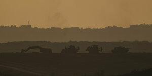 Ein israelischer Panzer und mehrere Bulldozer fahren im Gazastreifen, vom Süden Israels aus gesehen.