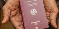 Eine Person hält einen deutschen Reisepass in den Händen.