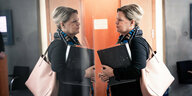 Bundesinnenministerin Nancy Faeser spiegelt sich in einer Glastür.