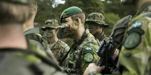 Schwedische Soldaten in Camouflage-Uniform und bemalten Gesichtern