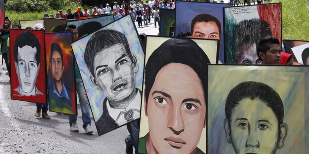 Teilnehmer eines Trauermarsches anlässlich des Jahrestages halten Portraits der Verschwundenen. Teilnehmer eines Trauermarsches anlässlich des Jahrestages halten Portraits der Verschwundenen.