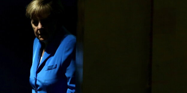 Angela Merkel steht im Dunkeln
