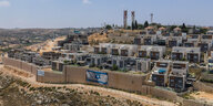 Israelische Siedlung mit Flagge an der Mauer.