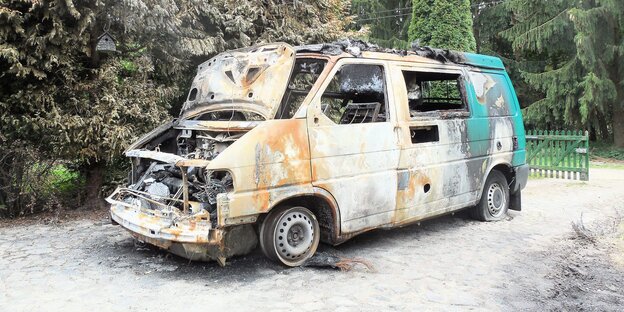 Ausgebrannter Transporter steht auf einem Weg