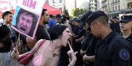 Eine Demonstrantin, die gegen die Regierung protestiert, schimpft auf die Polizei, die den Kongress bewacht, in dem die Gesetzgeber über einen vom argentinischen Präsidenten Milei eingebrachten Gesetzentwurf debattieren