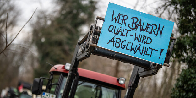 Trecker im Wald mit Schild: "Wer Bauern quält, wird abgewählt"