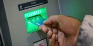 Die SozialCard für Asylbewerber aus Hannover wird in einen EC-Automaten gesteckt