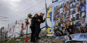 Ein Paar gedenkt am Zaun der Unglückstelle den Opfern des Zugunglücks