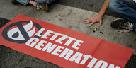 Banner der Letzten Generation und Hand auf der Straße