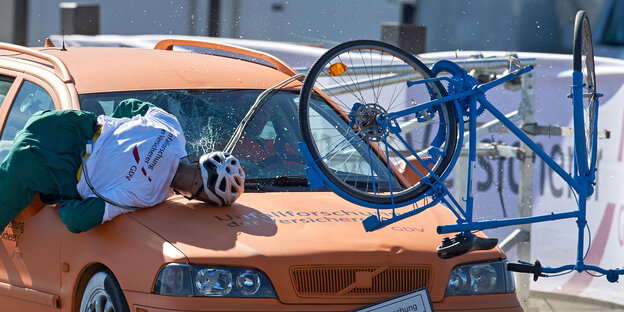 Eine Crash-Test-Puppe fliegt während eines simulierten Unfalls vom Fahrrad. Eine Crash-Test-Puppe fliegt während eines simulierten Unfalls vom Fahrrad.