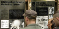 Besucher stehen vor Informationstafeln in der KZ-Gedenkstätte Langenstein-Zwieberge im Landkreis Harz.