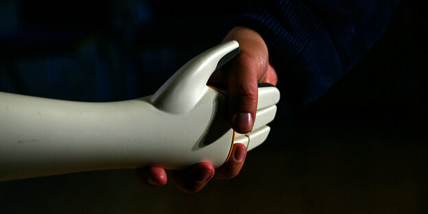 Een mens en een robot zijn hun eigen handen.