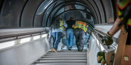 Ein Mann wird von zwei Polizisten auf einer Treppe zum Flugzeug geführt.