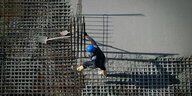 Ein Arbeiter ist auf einer Baustelle am Alexanderplatz beschäftigt, es wird Beton gegossen