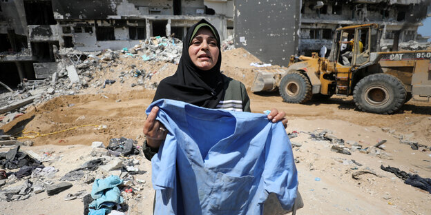 Een vrouw woont met een kledingstuk in de straat van Gaza