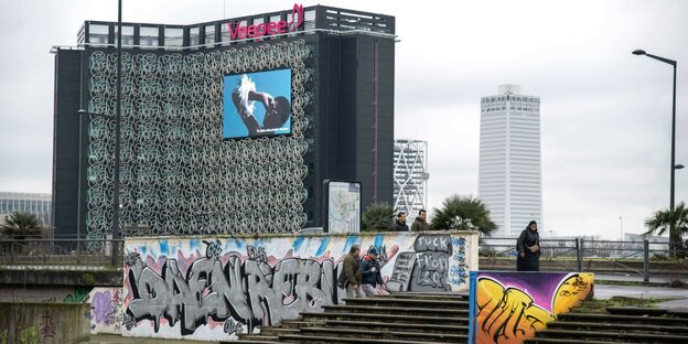 Hochhäuser in Paris, eine große Werbetafel, eine Treppe mit Graffiti