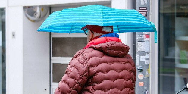 Een senior geniet van een regendouche.