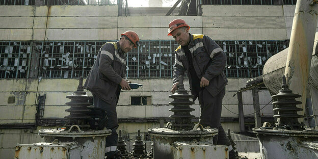 Voor het gebruik van een transformator zijn twee arbeiders met helm verplicht, waaronder een Russische Raketenangriff voor het DTEK Kraftwerk in Oekraïne.