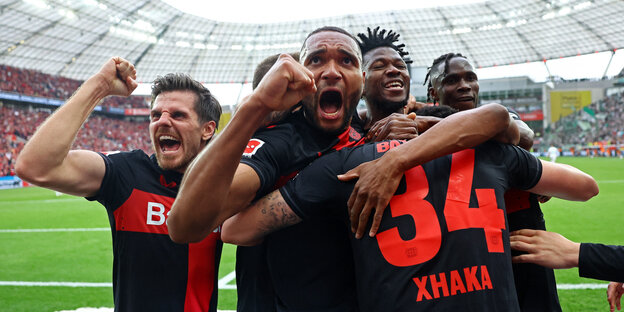 Leverkusener Spieler feiern ein Tor vor den Fans