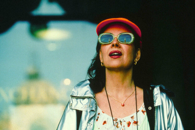 Schauspielerin Licia Maglietta trägt eine rote Mütze und Sonnenbrille und blickt nach oben