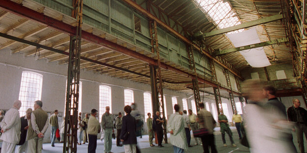 Menschen in der leerstehenden Schiffbauhalle der Rostocker Neptunwerft Menschen in der leerstehenden Schiffbauhalle der Rostocker Neptunwerft