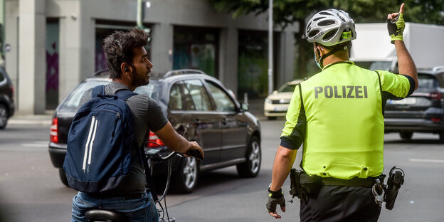 Ein Radfahrer wird von einem Polizisten angehalten