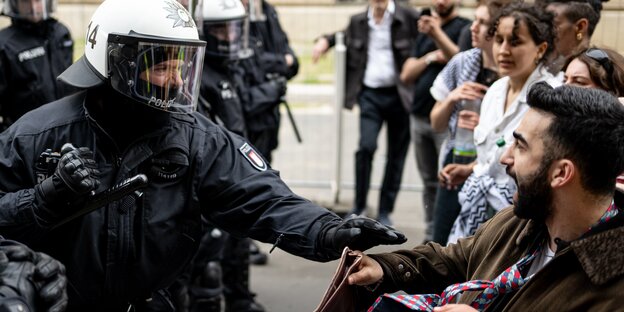 Ein Polizist und ein Demonstrant geraten bei einer Demonstration nach der Auflösung der „Palästina-Konferenz“ in Berlin-Mitte aneinander.