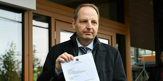 Thomas Heilmann steht mit einem DinA4-Blatt vor dem Bundesverfassungsgericht und hält sein Papier stolz in die Kamera