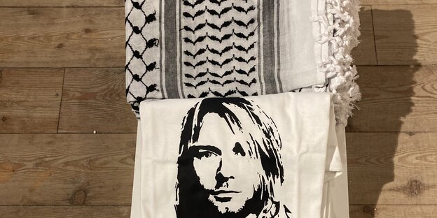 Ein T-Shirt mit dem Konterfei von Kurt Cobain liegt neben einem palästinensischen Schal.  Eine Installation von Emily Jacir