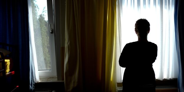 Frauensilhouette vor einem Fenster Frauensilhouette vor einem Fenster
