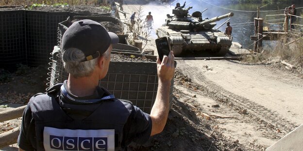 Ein OSZE-Beobachter und ein ukrainischer Panzer Ein OSZE-Beobachter und ein ukrainischer Panzer