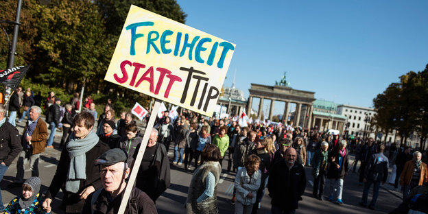 Viele Menschen vor dem Brandenburger tor in Berlin, einer trägt ein Schild mit der Aufschrift "Freiheit statt TTIP" Viele Menschen vor dem Brandenburger tor in Berlin, einer trägt ein Schild mit der Aufschrift "Freiheit statt TTIP"