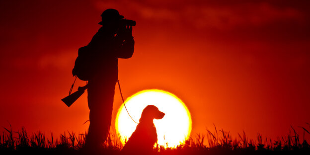 Jäger mit Hund und Fernglas