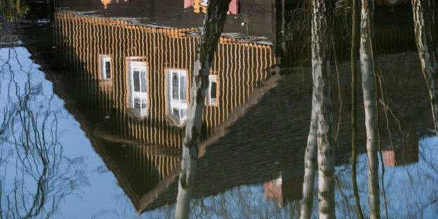Ein Haus in Brandenburg spiegelt sich in einer Pfütze. Ein Haus in Brandenburg spiegelt sich in einer Pfütze.