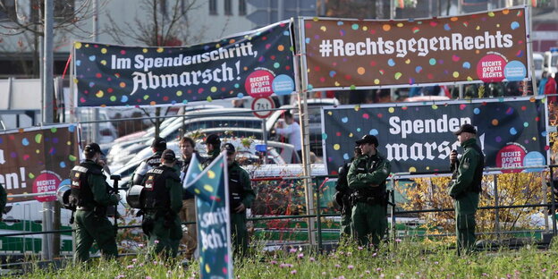 Polizisten stehen vor den Rechts-gegen-Rechts-Kampagneschildern bei der Hess-Gedenkdemo 2014. Polizisten stehen vor den Rechts-gegen-Rechts-Kampagneschildern bei der Hess-Gedenkdemo 2014.