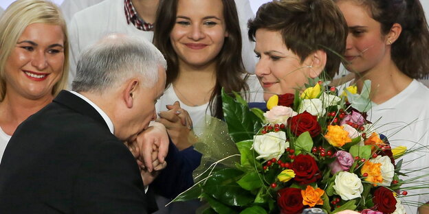 Kaczynski küsst die Hand von Szydlo, die einen Blumenstrauß trägt. . Kaczynski küsst die Hand von Szydlo, die einen Blumenstrauß trägt. .