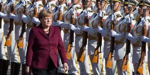 Angela Merkel läuft an einer Militärparade vorbei
