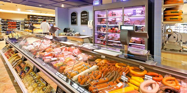 Reich bestückte Wursttheke in einem Supermarkt.