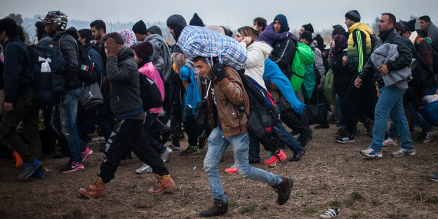 Flüchtlinge im slowenischen Rigonice auf dem Weg zu einem Bus. Flüchtlinge im slowenischen Rigonice auf dem Weg zu einem Bus.