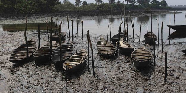 ölverschmutzte Kanus an einem See in Nigeria ölverschmutzte Kanus an einem See in Nigeria