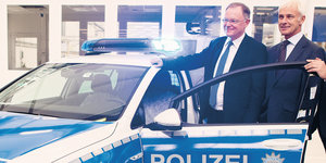 Ministerpräsident Stephan Weil und VW-Chef Matthias Müller vor einem Polizeiauto
