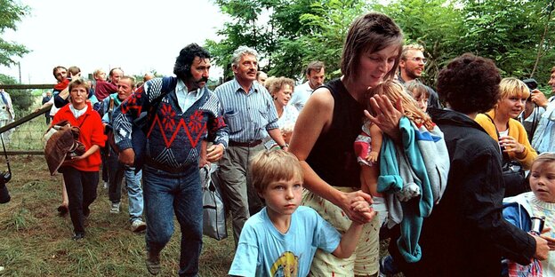Bild von 1989: Menschen laufen gehetzt über ein Feld Bild von 1989: Menschen laufen gehetzt über ein Feld