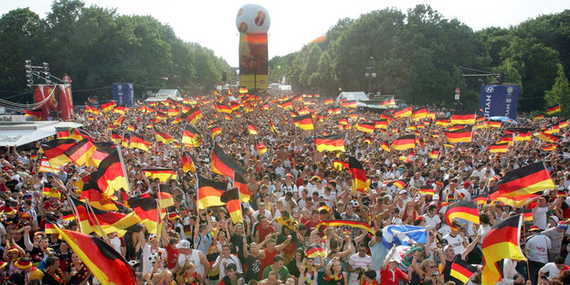 Fans der deutschen Fußball-Nationalmannschaft schwenken Fahnen während der Fußball-WM 2006 beim Fan-Fest in Berlin Fans der deutschen Fußball-Nationalmannschaft schwenken Fahnen während der Fußball-WM 2006 beim Fan-Fest in Berlin