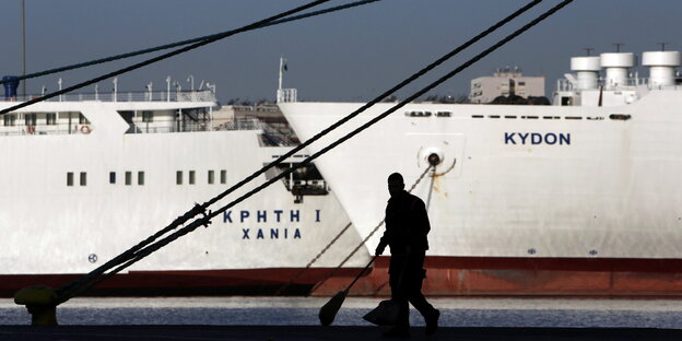 Straßenfeger vor einem Schiff im Hafen Straßenfeger vor einem Schiff im Hafen