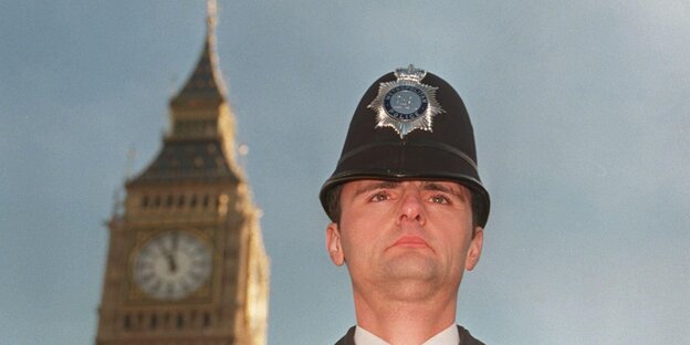 Ein behelmter britischer Polizist vor einem Turm Ein behelmter britischer Polizist vor einem Turm